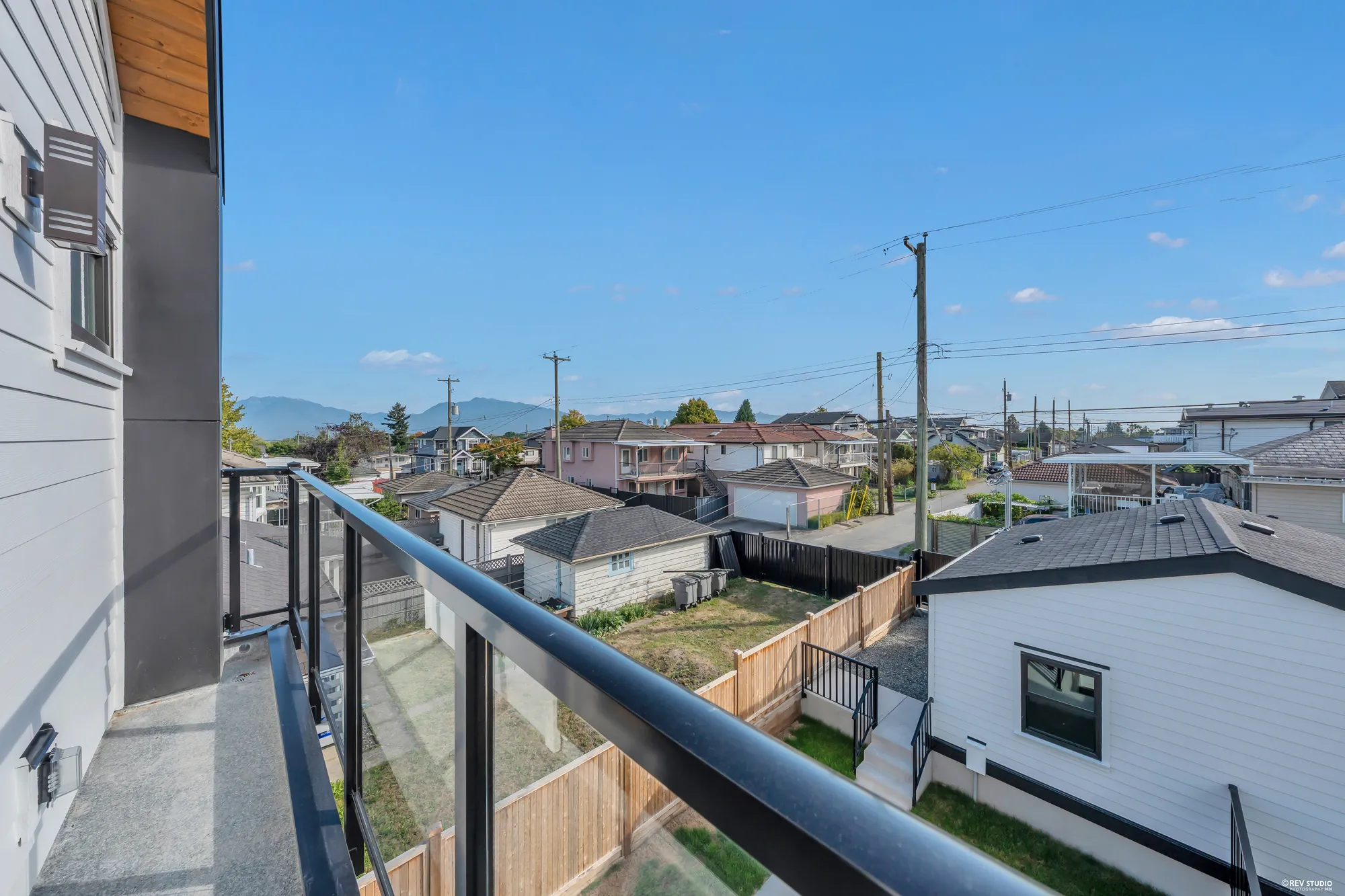 From the primary bedroom's balcony: the roofs of the neighbourhood and the North Shore mountains on the skyline
