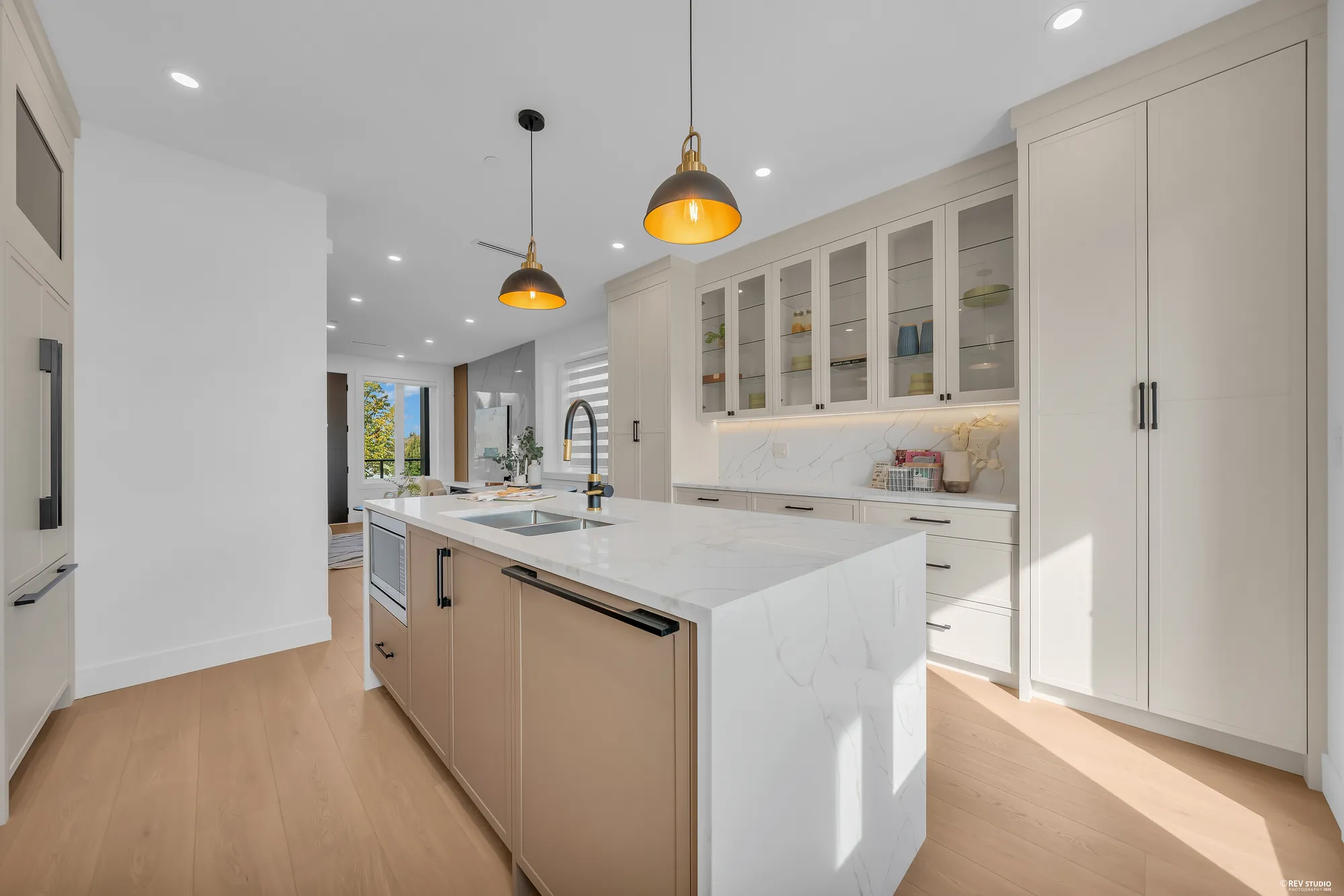 The kitchen toward the back door and the porch, the island on the left