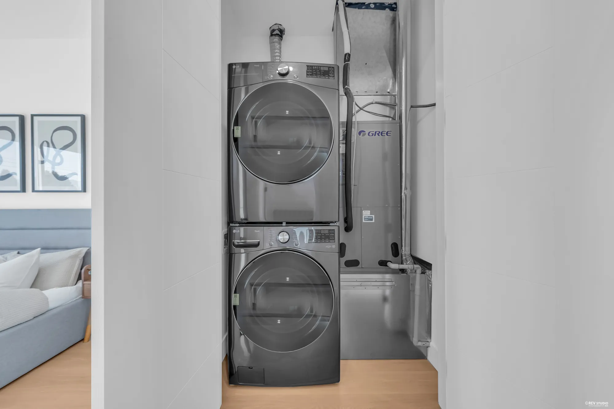 A stacked washer and dryer in the hall closet, the heating unit beside them